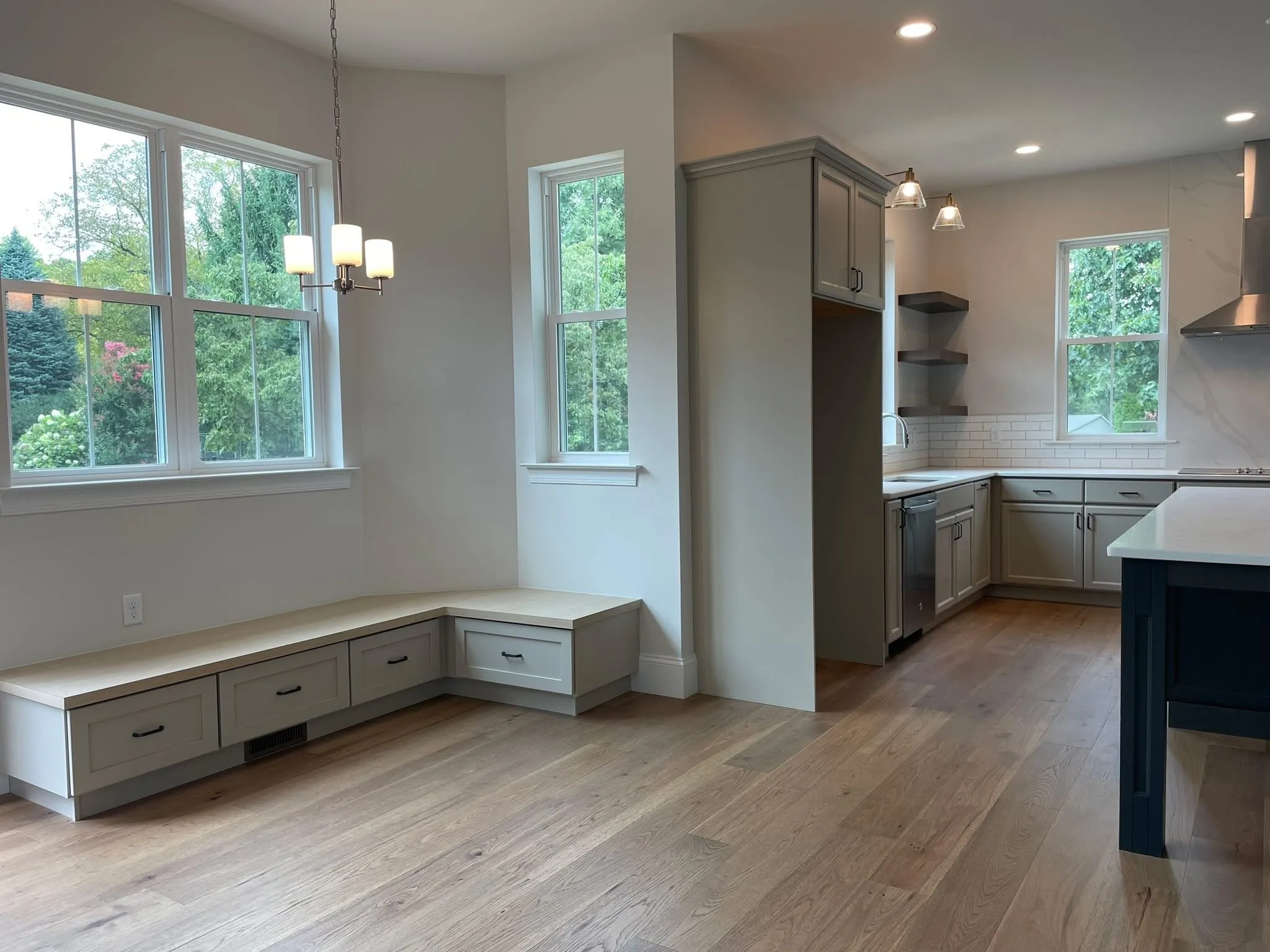 A built-in corner bench with drawers sits in a bright kitchen breakfast nook area.