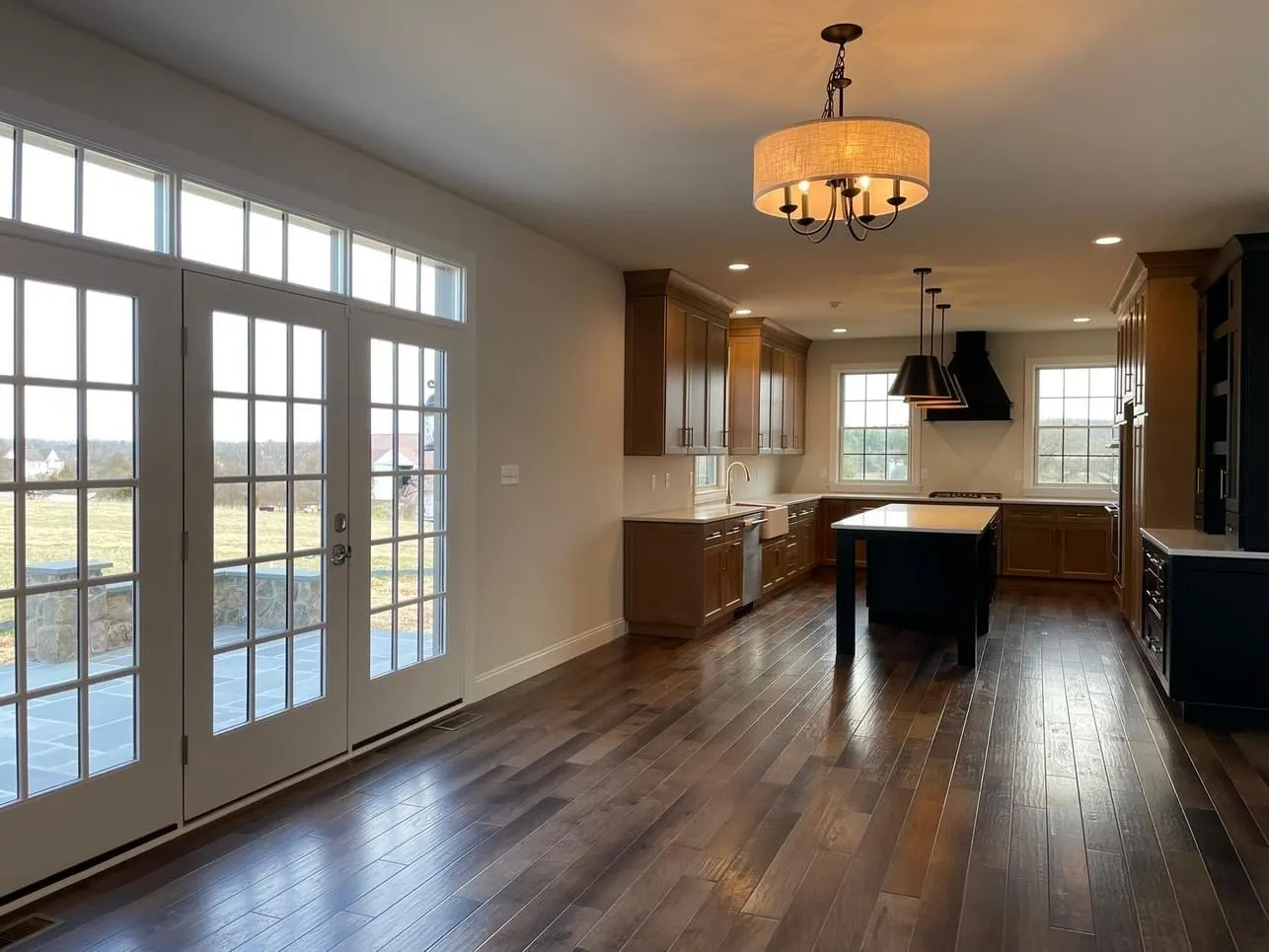 A spacious kitchen featuring dark wood cabinetry, a central island, and hardwood floors throughout the room.