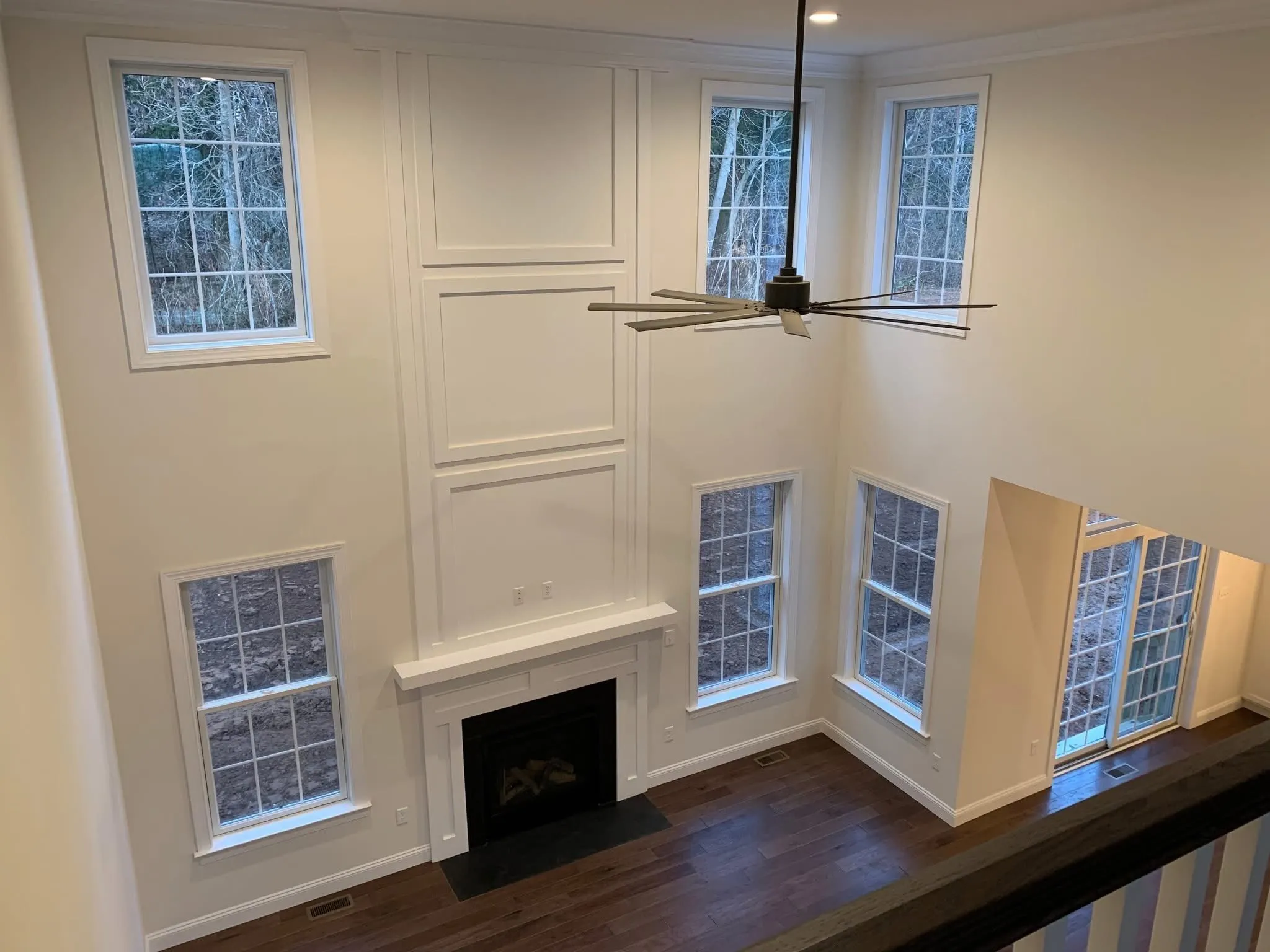 A two-story fireplace surround features white panel molding extending from the mantel to the ceiling.