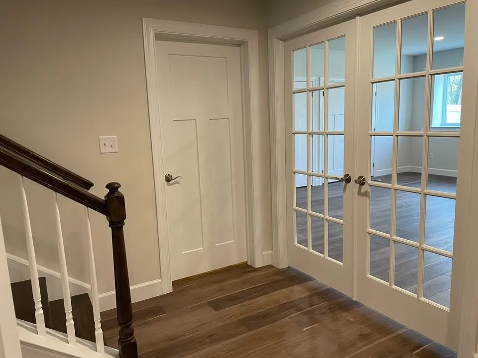 White french doors and a single panel interior door installed with matching white casing.